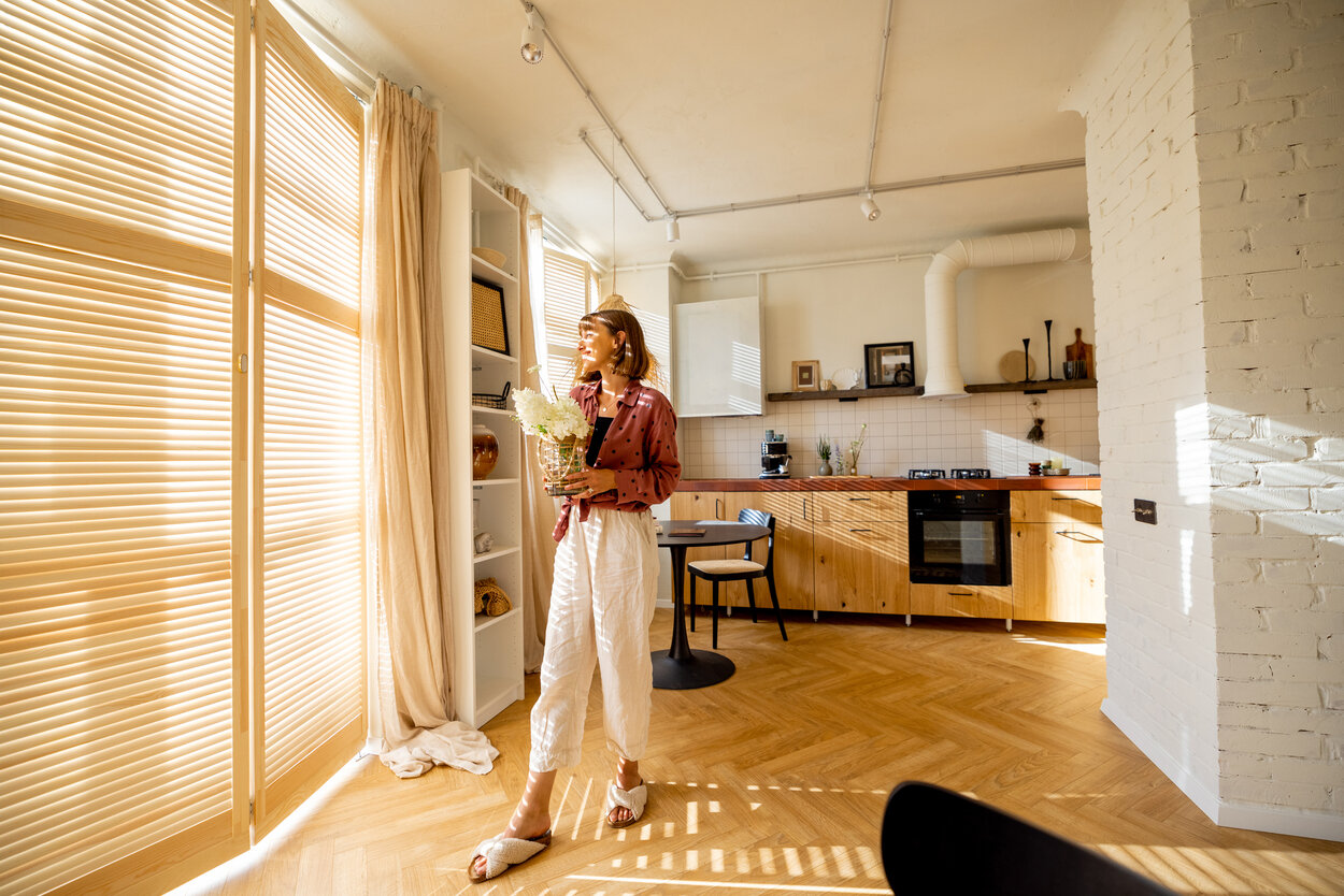 Woman with flowers in a sunny apartment.